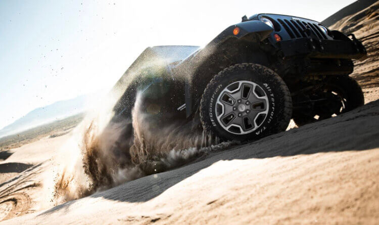 A jeep driving up a sandy hill on a bfgoodrich at k02 tyre showing off its Superior Traction