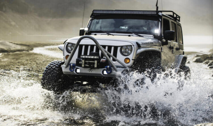 A jeep drive through water making a big splash sat on bfgoodrich km3 TYRES