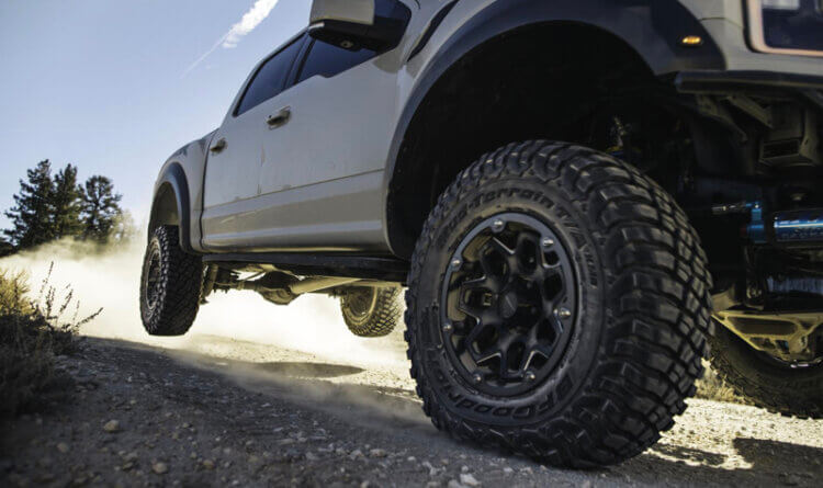 A large 4x4 truck landing on road back KM3 tyres still in the air - bfgoodrich km3 tyres
