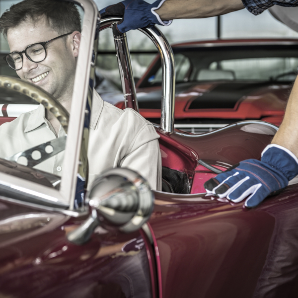 a happy driver sat in a classic car using classic car tyres and how to Understanding Classic Car Tyres