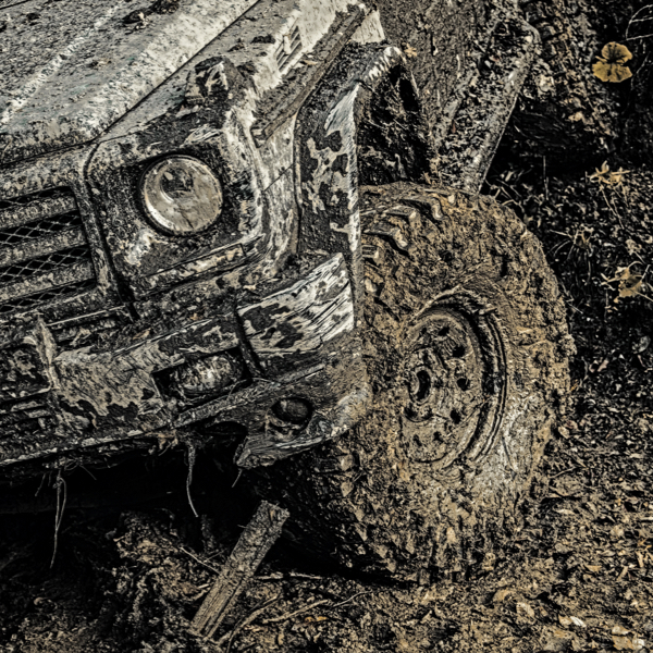 A 4x4 moving through heavy mud showing how Mud Terrain Tyres off have road durability