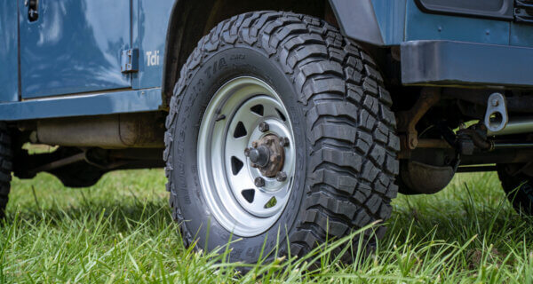 aftermarket steel wheels UK sat on a classic land rover in a field