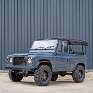 A blue vintage land rover sat black steel wheels